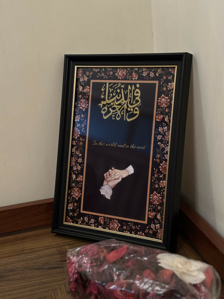 A4-sized black carved frame featuring gold “Fiddunya Wal Aakhira” calligraphy with an elegant couple hand illustration, luxury Islamic wedding decor.