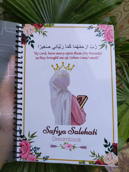 Crown Girl Customized Notebook with personalized name and design. This notebook features full-color pages, spiral binding, A5 size, and a soft transparent cover, and includes a free non-tearable bookmark. The cover displays the name 'Safiya Salehati Dreambook' with an elegant Islamic design, showcasing a woman holding a Quran, surrounded by floral decorations.